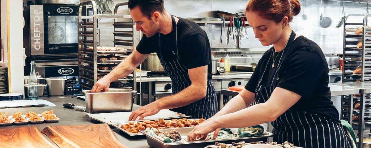 Two culinary arts students working in a kitchen
