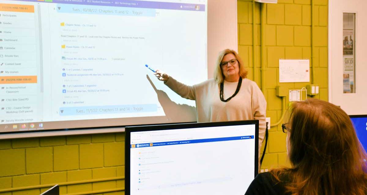 Medical Coding instructor standing in front of a monitor