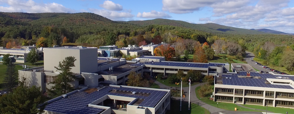 An overhead shot of the BCC campus, showing solar panels on the roofs of campus buildings and mountains beyond
