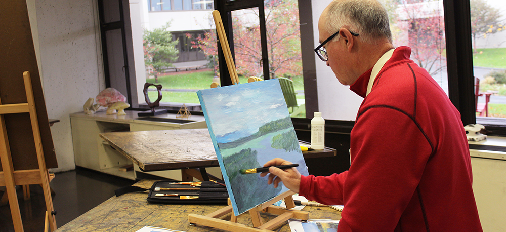 A student works on a painting in a BCC Visual Arts studio